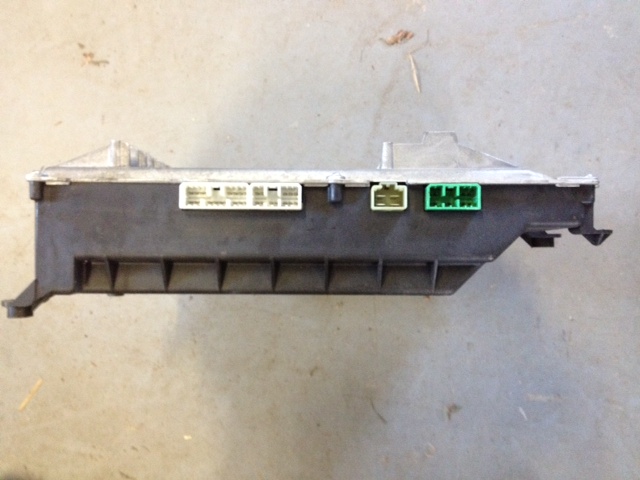 Automotive electronic control module with green, light green, and white connectors.