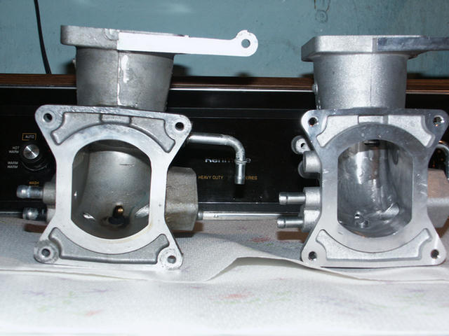 Two aluminum throttle bodies side by side comparing bore sizes