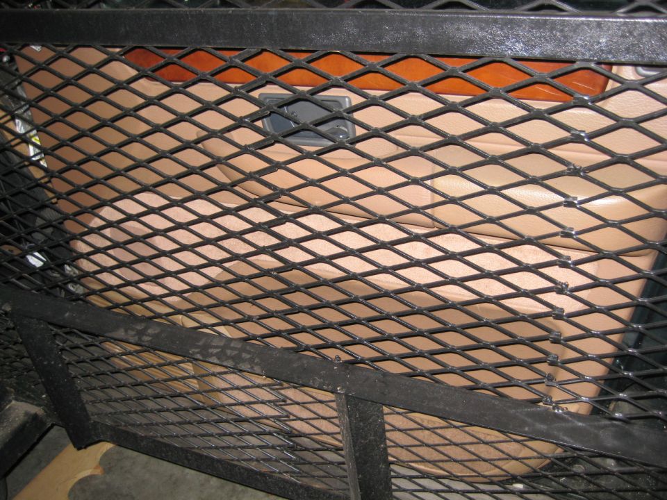 Tan leather seat visible through a diamond metal grate.