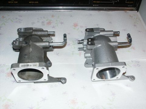 2001 Mercury Grand Marquis - Comparison of a used throttle body and a new one, likely for an automotive application.