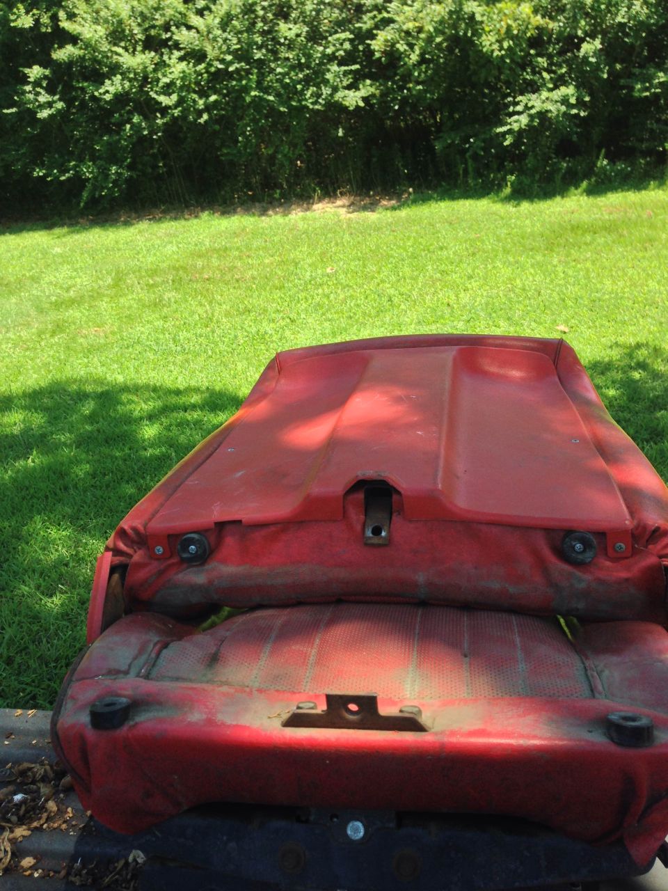 Weathered red vehicle seat outdoors