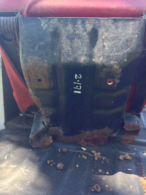 1979 Ford Bronco - A close-up view of the heavily rusted black metal underside of a vehicle seat. White handwritten text on the metal reads "2-1-78".