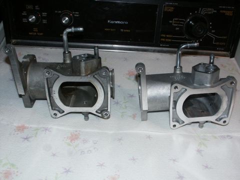 2001 Mercury Grand Marquis - Two intake plenums are shown side-by-side on a patterned cloth, with a Kenmore appliance in the background.