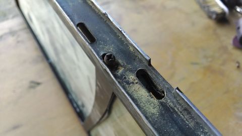 1992 Ford Bronco - A close-up view shows a rusty metal frame with a single screw and two elongated slots. The frame appears to be part of a vehicle component,…