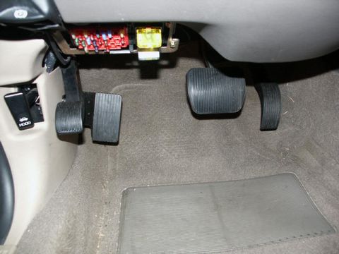 2001 Mercury Grand Marquis - The interior of a vehicle displays the brake, gas, and dead pedals, along with an accessible fuse box.