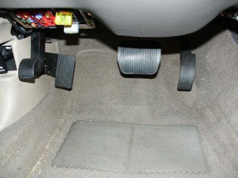 2001 Mercury Grand Marquis - Interior view of the driver's side footwell, highlighting the pedals and fuse box.