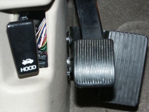 2001 Mercury Grand Marquis - Close-up of the hood release lever and brake and accelerator pedals within a vehicle's interior.