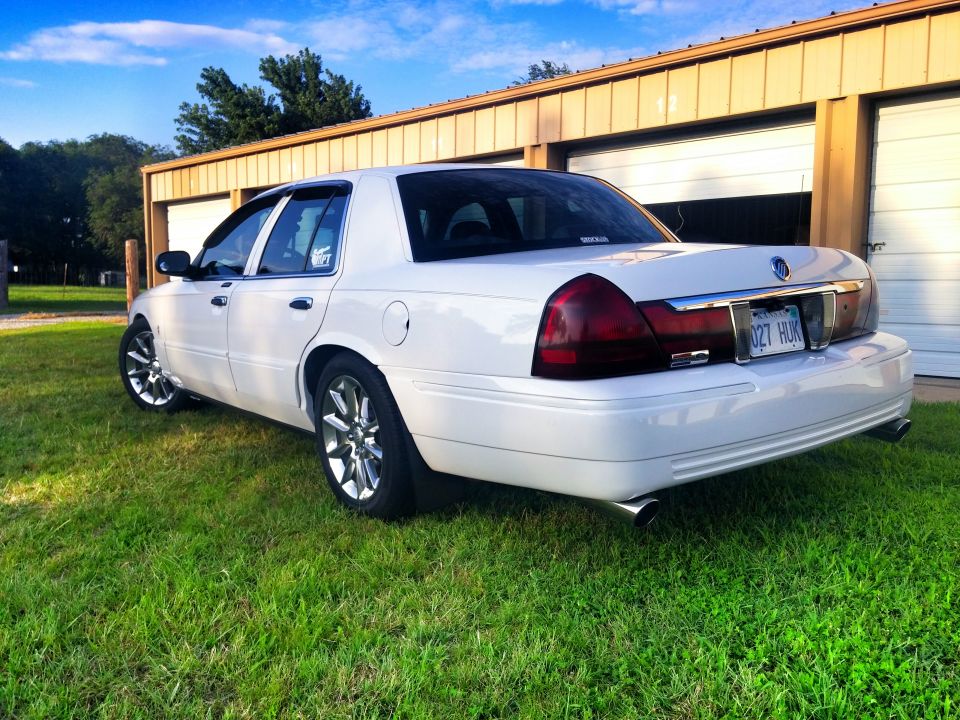 White Mercury Grand Marquis sedan, rear quarter view on grass