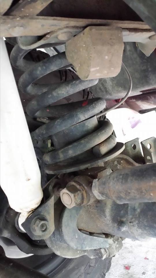 Rear suspension of a 1995 Ford Bronco, showing coil spring, shock, and axle.