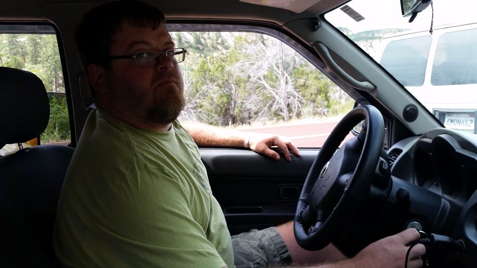Man in driver's seat of a vehicle, interior view.