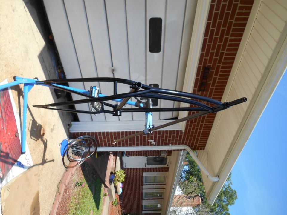 Black bicycle frame on a blue repair stand