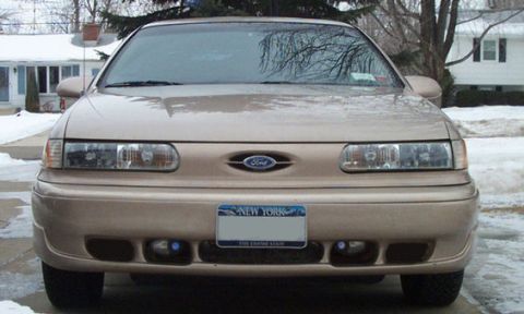 1993 Ford Taurus - Frontal view of a tan 1992 Ford Taurus, showing its headlights, grille, and license plate.