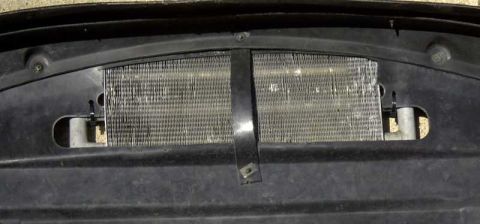 1997 Ford Taurus - Close-up of a transmission cooler with visible fins and mounting hardware.