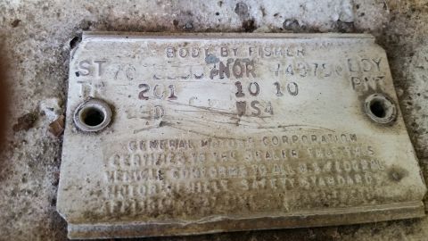 2015 Chevrolet new - A close-up view of a weathered VIN plate from a vintage vehicle, likely a Chevrolet, with faded text indicating 'BODY BY FISHER' and 'GENER…