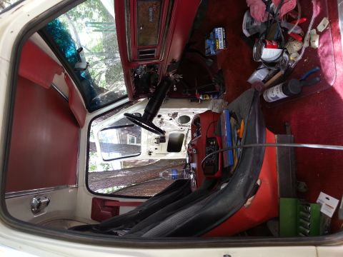 1978 Ford Bronco - The interior of a vintage truck or SUV, possibly a 1978 Ford Bronco, shows a red and black color scheme with the dashboard, steering wheel,…