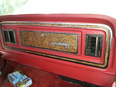 1978 Ford Bronco - The interior dashboard of a classic Ford truck or SUV features a wood grain trim panel with "RANGER XLT" text. The panel is surrounded by r…