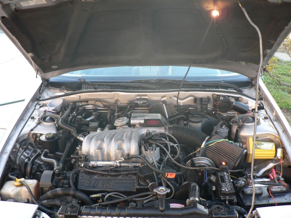 1991 Ford Probe engine bay with 3.0L V6 engine, air intake, and battery.