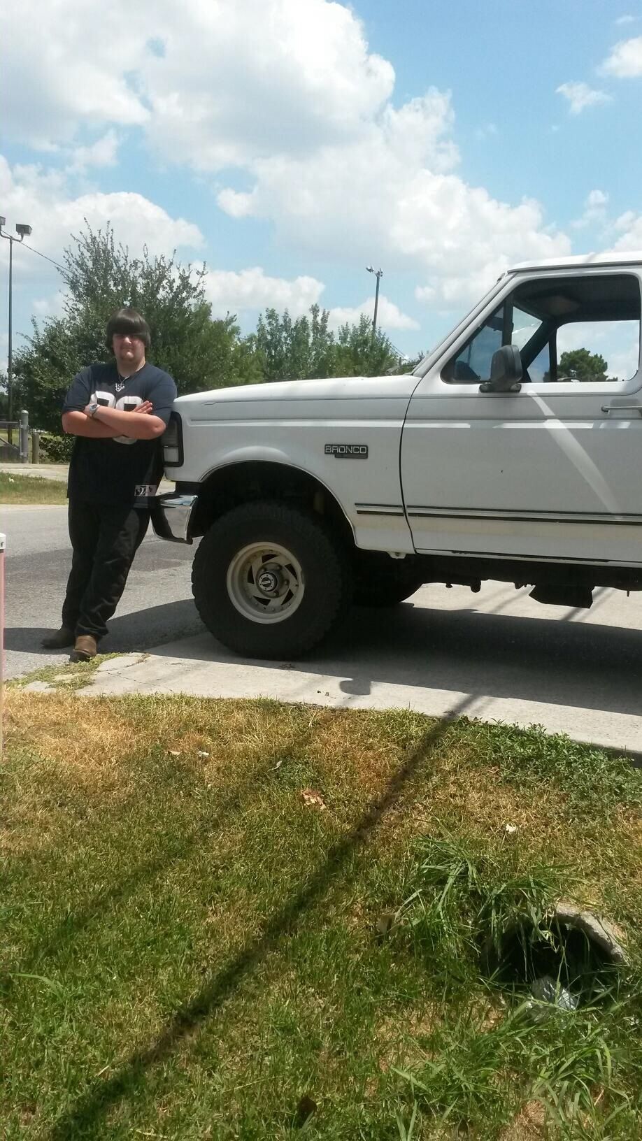 Man leaning on a white Ford Bronco.