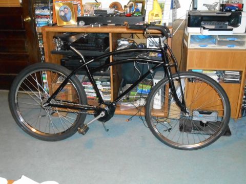 Black bicycle with chrome handlebars and wheels, seen from the side