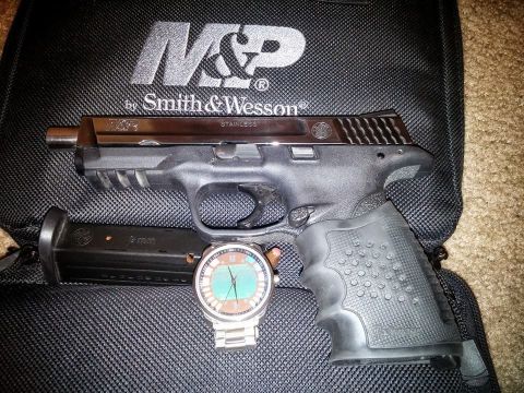 2000 Mercury Grand Marquis - A Smith & Wesson M&P pistol, magazine, and wristwatch are displayed on a branded bag.