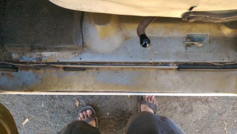 1968 Chevrolet C/K Pickup - The interior floor and door sill of a vehicle are visible, with a black shift knob and part of the seat.