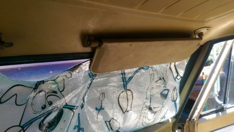 1968 Chevrolet C/K Pickup - The interior of a vehicle shows a sun visor and a window shade with cartoon characters.