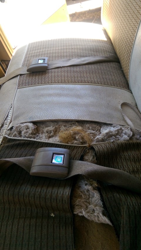 1968 Chevrolet C/K Pickup - The interior of a vehicle seat shows significant wear and tear, with a visible digital clock displaying 1:02.