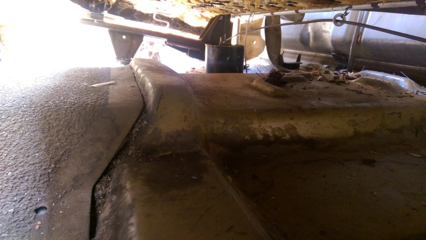 Underside view of a vehicle, showing the fuel tank and frame components