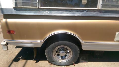 1968 Chevrolet C/K Pickup - Side view of a gold and white pickup truck, highlighting the rear wheel and bed section.