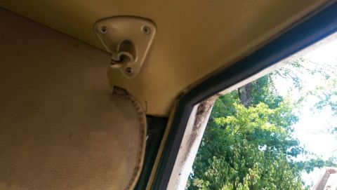 1968 Chevrolet C/K Pickup - Close-up of the interior of a vehicle, focusing on the sun visor and window trim.