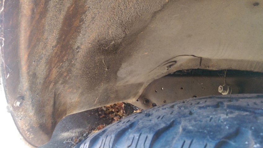 Truck wheel well with rust and a tire visible. A Supermotors logo is in the corner