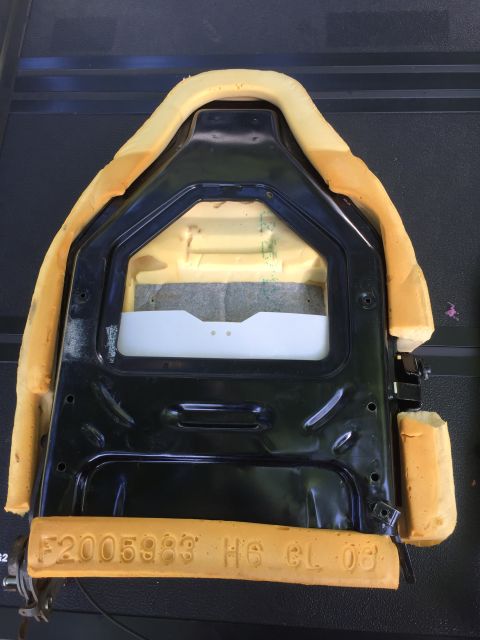 1994 Ford Bronco - A car seat frame with foam padding is shown, embossed text that may indicate part or manufacturing details.