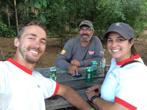 1946 Jeep CJ5 - Three friends enjoy drinks and conversation at a picnic table in a wooded area.