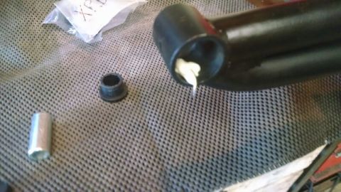 1992 Ford Bronco - A suspension component is prepared for installation with grease and a new bushing.