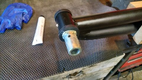 1992 Ford Bronco - Suspension part assembly with grease and a glove, likely for vehicle maintenance.