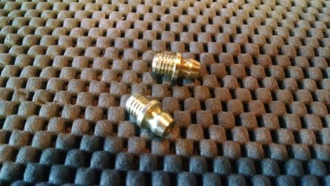 1992 Ford Bronco - Two brass fittings are shown on a textured surface.