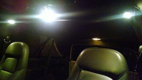 1992 Ford Bronco - The interior of a vehicle is illuminated by dome lights, highlighting the seats and ceiling.