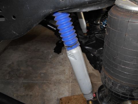1992 Ford Bronco - Close-up view of a shock absorber with a blue protective boot and an adjacent air spring.