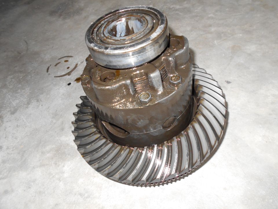Differential gear assembly with a bearing on top, resting on a concrete surface