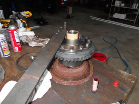 1992 Ford Bronco - A differential assembly is shown on a workbench, surrounded by various tools and automotive maintenance supplies.