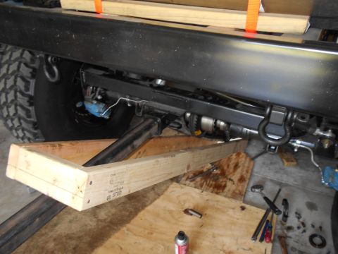 1992 Ford Bronco - The underside of a vehicle is shown with wooden supports and visible mechanical components.