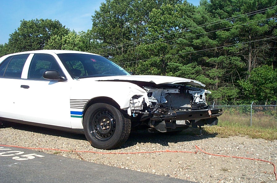 White 2001 Ford Crown Victoria with damaged front end, seen from a 3/4 front angle