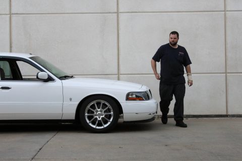 2000 Mercury Grand Marquis - A white sedan is shown from the side with a man standing next to it.