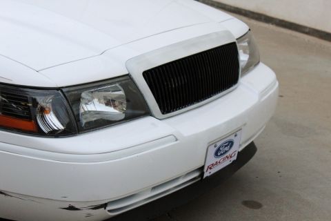 2000 Mercury Grand Marquis - The front grille and headlights of a white sedan are visible, along with a license plate holder indicating 'Ford Racing'.