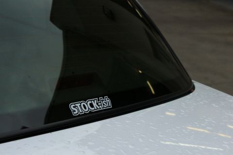2000 Mercury Grand Marquis - A white car with a 'STOCK-ish' sticker on its rear window.