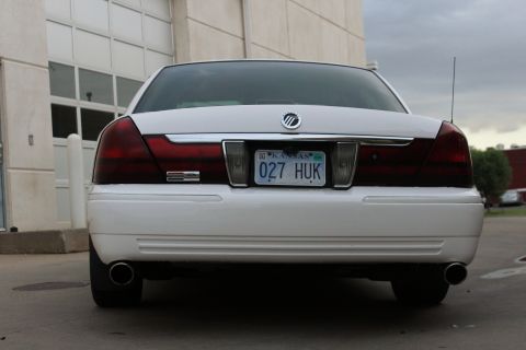 2000 Mercury Grand Marquis - The rear of a white Mercury Grand Marquis is shown parked in front of a building.