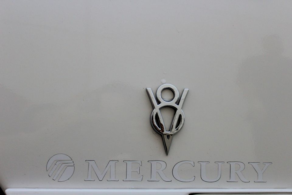 White Mercury V8 badge and lettering on car
