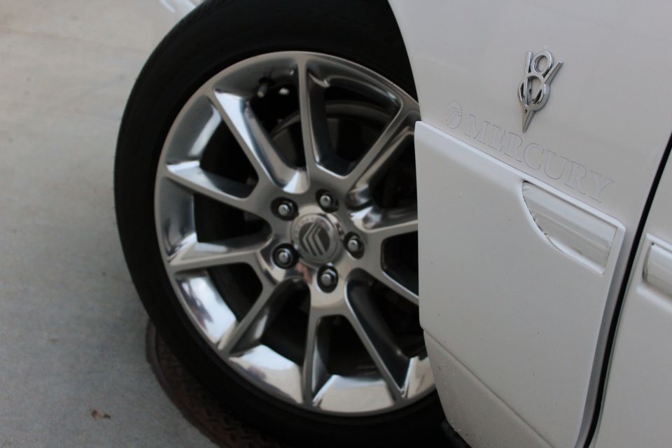 Close-up of a 2000 Mercury Grand Marquis wheel and fender with V8 emblem