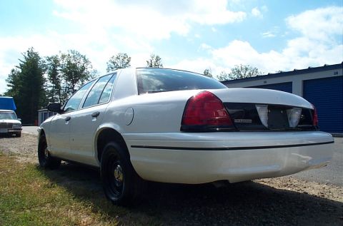 2001 Ford Crown Victoria - Rear view of a white 2001 Ford Crown Victoria parked outdoors on a sunny day.