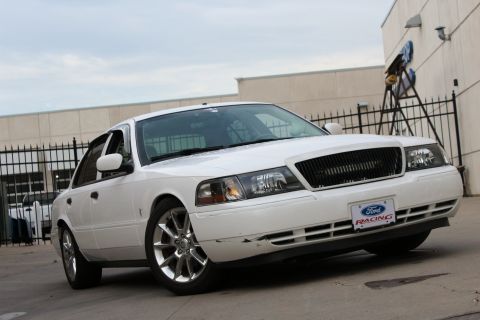 2000 Mercury Grand Marquis - White sedan with a black grille and a Ford Racing license plate frame parked outside.